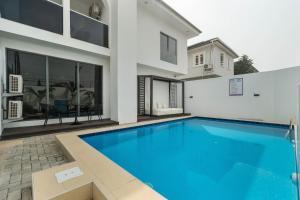 a swimming pool in front of a house at Aima Apartments in Lekki