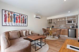 a living room with a couch and a kitchen at Aima Apartments in Lekki