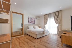 a bedroom with a white bed and a large window at Aima Apartments in Lekki