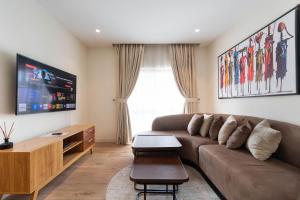 a living room with a couch and a flat screen tv at Aima Apartments in Lekki