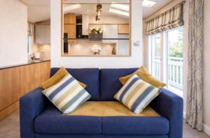 a blue couch with two pillows in a living room at The View Point Northumberland in Newton on the Moor