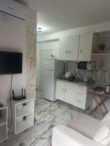 a kitchen with white cabinets and a marble floor at Apartamento 1 dorm,com ar,frente faculdade in São Paulo