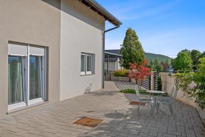a patio with chairs and a table in front of a building at House Degenia in Lovinac