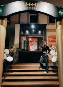 a man sitting on the stairs in front of a store at Pension Villa Grün in Zwickau