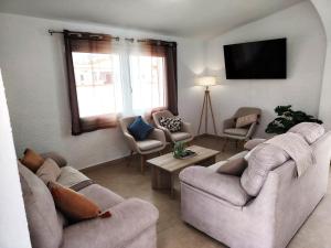 a living room with couches and chairs and a flat screen tv at Villa OM, Piscina Privada, Aire Acondicionado Free in L'Escala