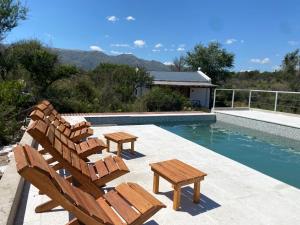 a pool with chairs and a table next to a swimming pool at Estación Tachyón Timalu , ETe-Nea in San Esteban