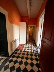 an empty room with a checkered floor and a refrigerator at Le Jasmin in Lure