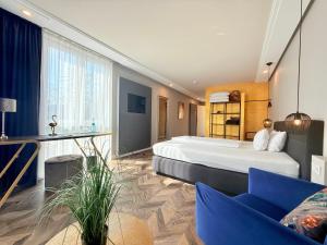 a hotel room with a large bed and a couch at Boutique Hotel Zuckerfabrik Stuttgart in Stuttgart