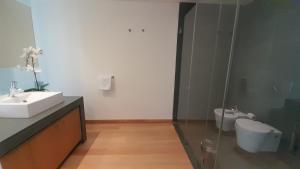 a bathroom with a sink and a toilet at Tróia Oasis Villa in Troia