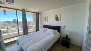 a bedroom with a large bed and a large window at Viabo in Viña del Mar +47 photos