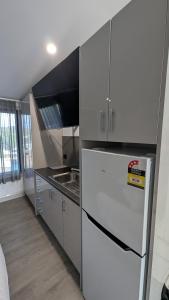a kitchen with a white refrigerator and a sink at Cooma High Country Motel in Cooma +43 photos