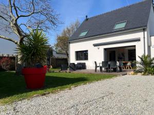 a white house with a patio with a table and chairs at MAISON NEUVE LUMINEUSE AU CALME PROCHE DES PLAGEs in Quiberon