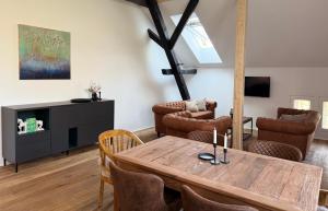 a living room with a wooden table and chairs at Gut Osterhausen in Butjadingen