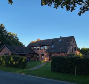 a large brick house with a black roof at Ferienwohnung Am Museum in Dötlingen