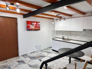 a kitchen with white cabinets and a table and chairs at Arius King in Satu Mare +7 photos