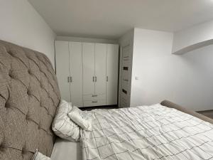 a bedroom with a large bed and white cabinets at Arius King in Satu Mare