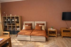 a bedroom with a bed with an orange blanket at Apartment Riviera 13 Lipno in Lipno nad Vltavou +8 photos