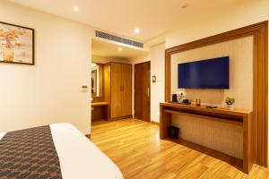 a hotel room with a bed and a flat screen tv at Liza Royale Hotel Near Chennai central Railway Station in Chennai +53 photos