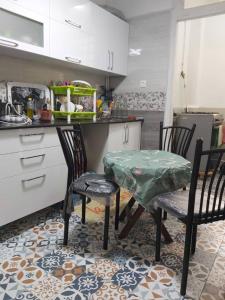 a kitchen with two chairs and a table and a counter at Appartcirta in Constantine