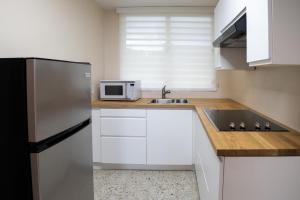 a kitchen with a stainless steel refrigerator and a sink at Blue Lodge in Manati