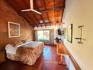 a bedroom with a bed and a brick wall at ANAPOIMA Toscana in Anapoima +59 photos