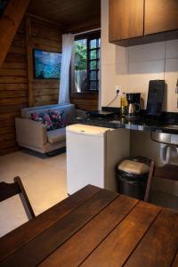 a kitchen with a table and a couch in a room at Vilarejo Hospedagem - Encantadas in Ilha do Mel