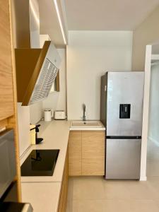 a kitchen with a stainless steel refrigerator and a sink at Sea View Apartment - Residence Les Sablettes in Menton
