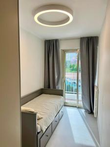 a bedroom with a bed and a large window at Sea View Apartment - Residence Les Sablettes in Menton