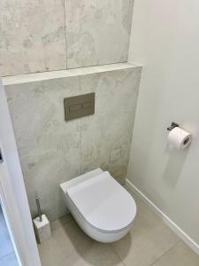 a bathroom with a white toilet and a roll of toilet paper at Sea View Apartment - Residence Les Sablettes in Menton +12 photos