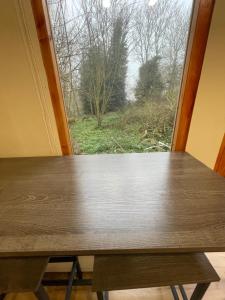 a wooden table in front of a window at Rectory Hideaway in Reedham