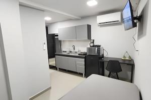 a kitchen with a black counter and a microwave at Studio IX - Com Ar Condicionado - Jundiaí in Jundiaí +3 photos
