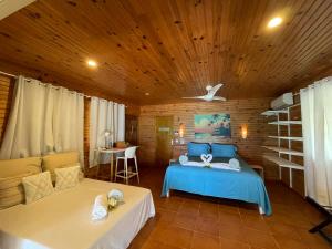 a bedroom with a blue bed and a couch at Rangiroa Sunny House in Avatoru