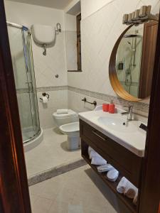a bathroom with a sink and a toilet and a mirror at Due Passi dal Gate in Salerno Airport - Aeroporto di Salerno +17 photos