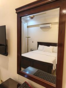 a mirror reflecting a bed in a room at The Aristocrat Manor in Islamabad