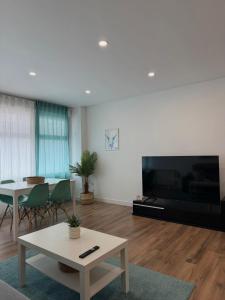 a living room with a large television and a table at Bruma in Vilagarcia de Arousa