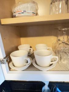 a shelf with cups and saucers on it at New York Flushing private room in Flushing