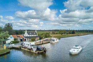 two boats docked at a dock on a river at Rectory Hideaway in Reedham +6 photos