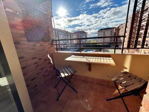 a balcony with two chairs and a table on a building at Apto La Estambrera IV Wifi y Aire Acondicionado in Logroño