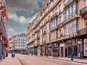 a city street with tall buildings and people walking down the street at Vandenbranden Suites in Brussels
