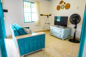 a living room with a blue couch and a television at Finca La Molienda, espléndido Mirador del Quindio in Circasia
