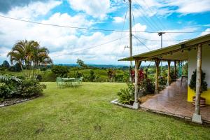 a house with a yard with a table and chairs at Finca La Molienda, espléndido Mirador del Quindio in Circasia