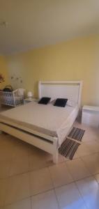 a bedroom with a bed with white sheets and pillows at Apart savane in São Filipe