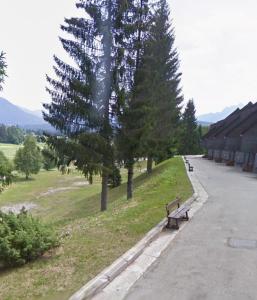 a park with benches and trees on the side of a road at Erika in Tarvisio