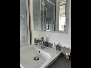 a white sink in a bathroom with a mirror at Garden House Rooms in Kirkwall