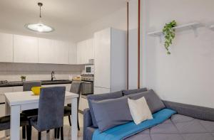 a living room with a blue couch and a kitchen at Perla del Salento in Brindisi