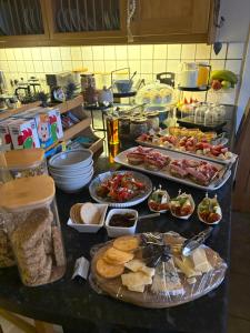 a kitchen counter with many plates of food on it at Waterside House B&B in Ullapool