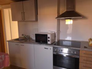 a kitchen with a microwave and a stove at Ferienwohnung Sonne in Bad Staffelstein