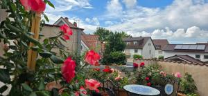 a patio with tables and chairs and red roses at Ferienwohnung Sonne in Bad Staffelstein