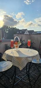 a table with two wine glasses on a balcony at Ferienwohnung Sonne in Bad Staffelstein