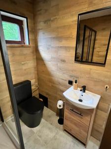 a bathroom with a sink and a chair in it at Domek u Patryka in Mrągowo